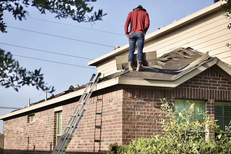 Professional roofer working on a residential roof in Scriba